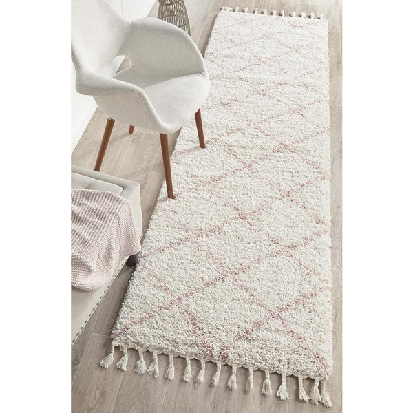 Pink and white Moroccan-inspired shaggy runner rug with diamond pattern and tasseled edges.