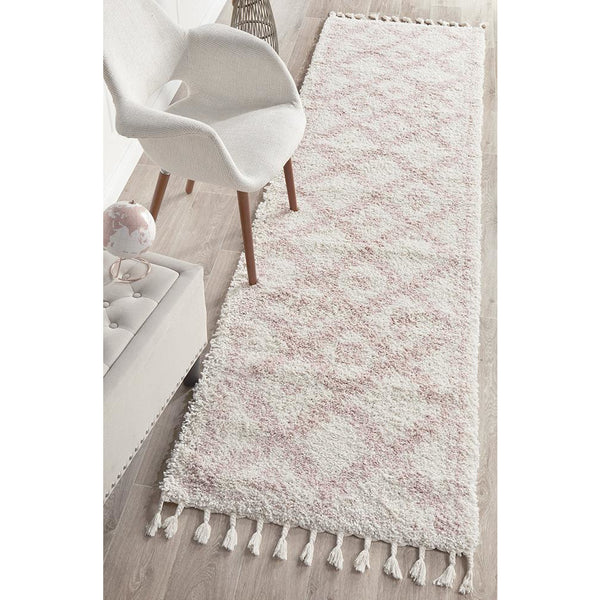 Pink Moroccan-inspired shaggy runner rug with geometric tribal patterns and tassels on both ends.