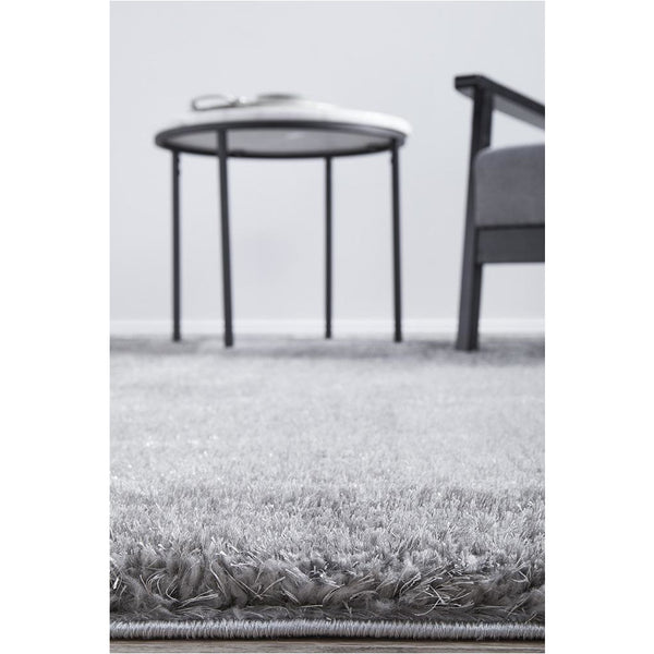 Silver grey rectangular shaggy rug with soft, dense polyester pile on light floor.