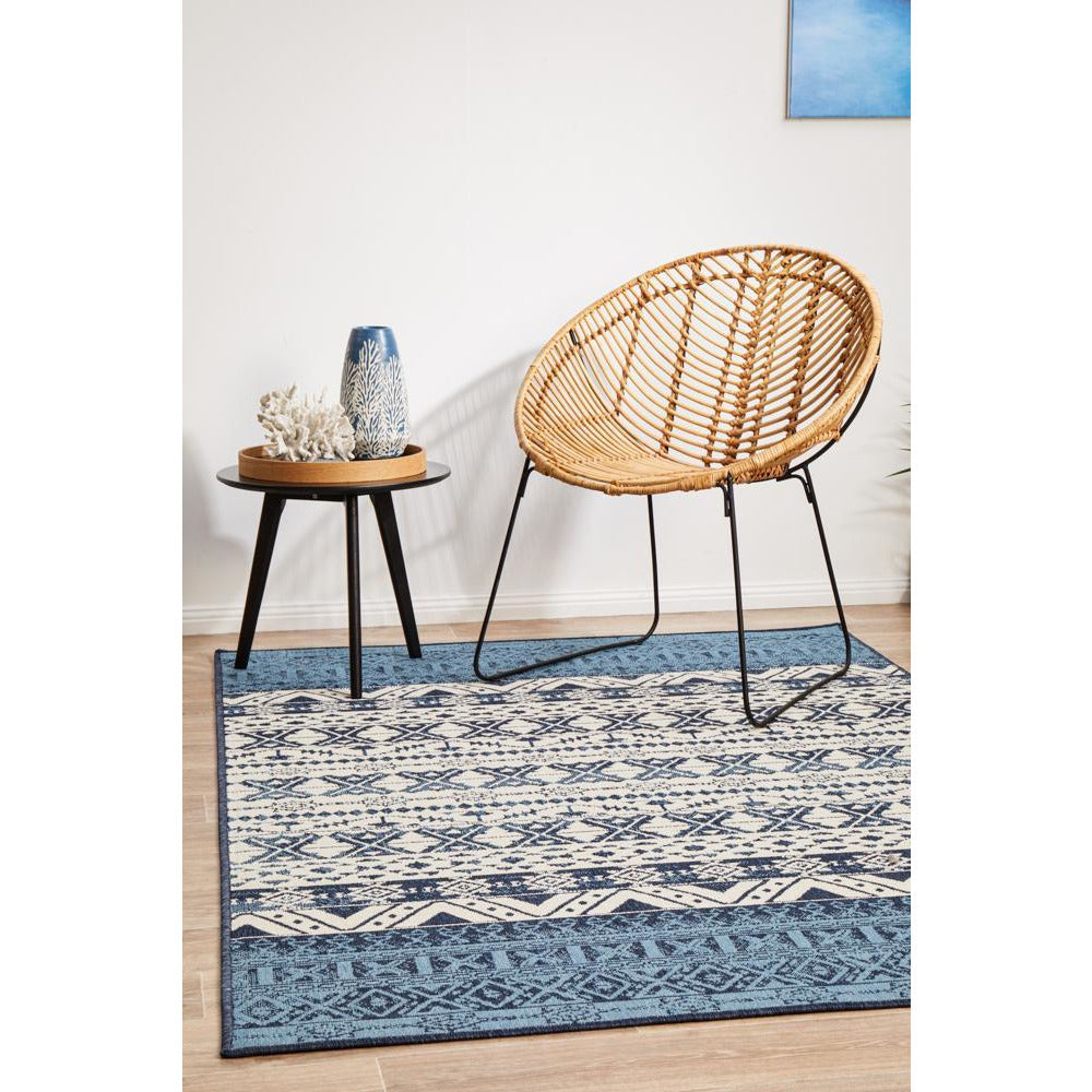 Rectangular blue and white tribal patterned rug with modern geometric designs on hardwood floor.