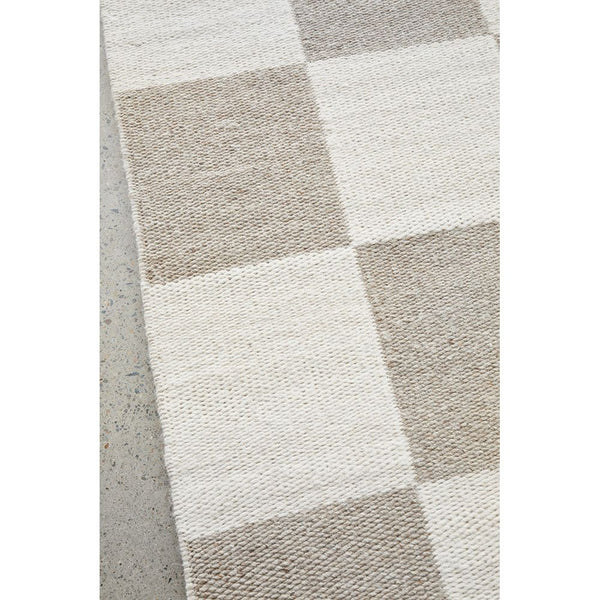 Neutral-toned wool blend rug with large checkerboard pattern in beige and cream.