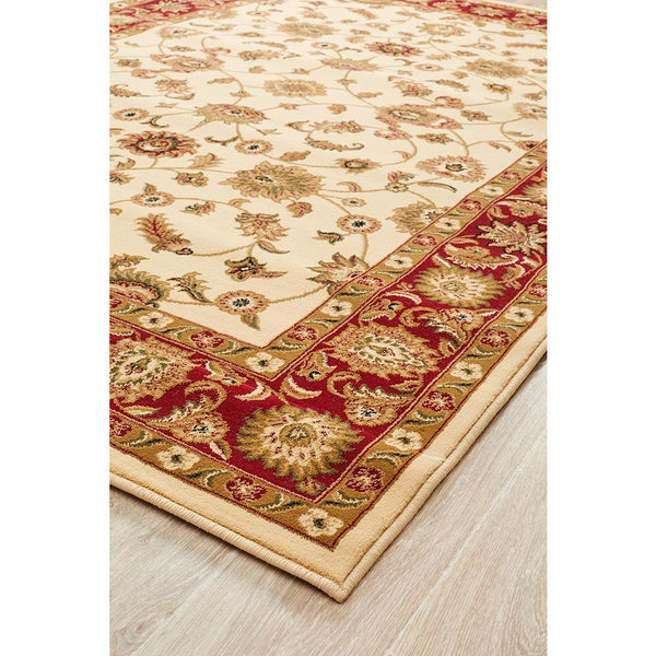 Ivory rug with intricate floral patterns and a wide red border featuring traditional motifs.