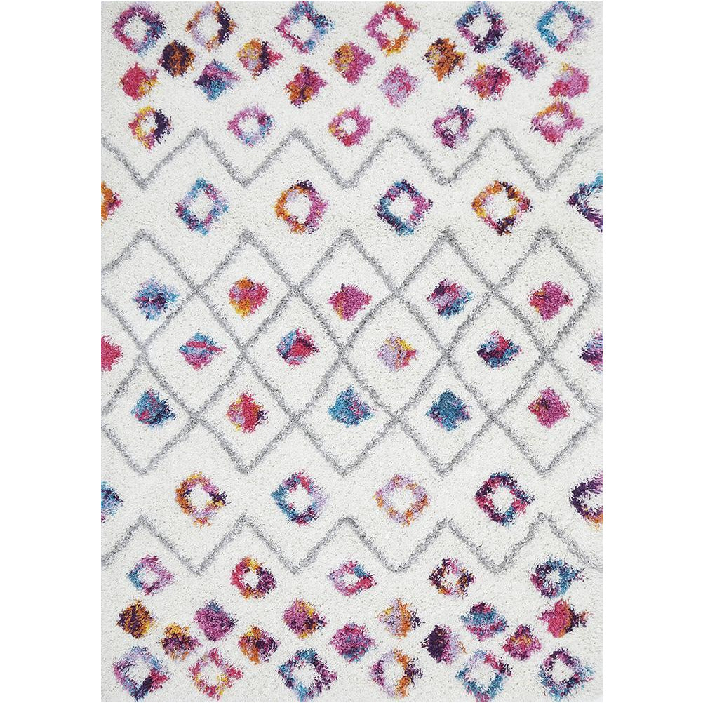 Rectangular white shaggy rug with multicolor Moroccan diamond and dot patterns in pink, blue, and orange.