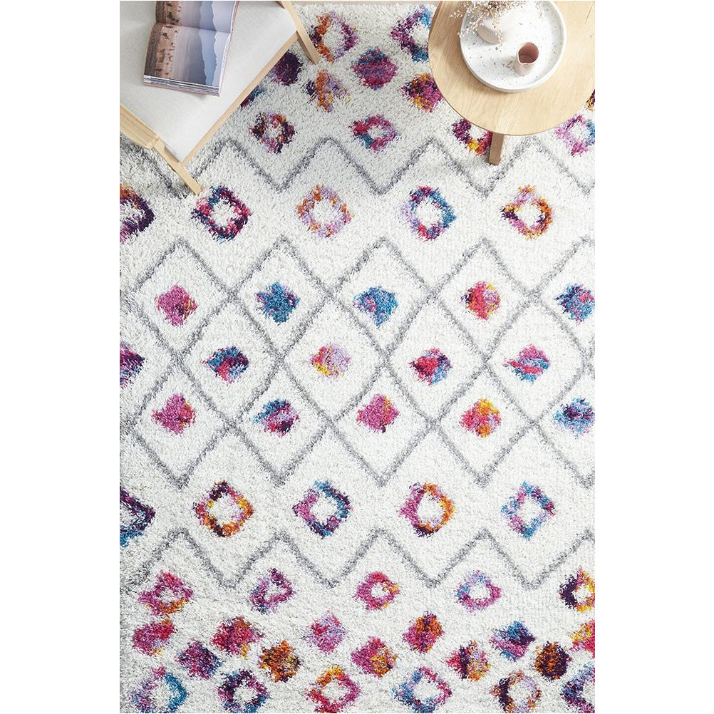 Multi-color Moroccan style shaggy rug with diamond and abstract patterns on white background.